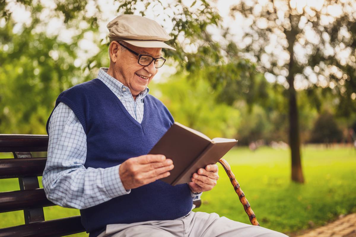 Senior man reading outdoors — cognitive health and mental clarity